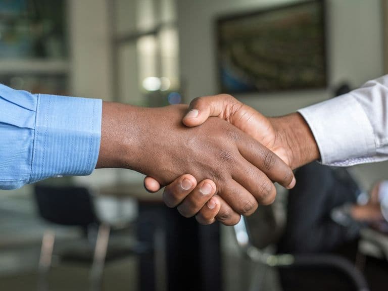 Two people shaking hands, representing patient referrals