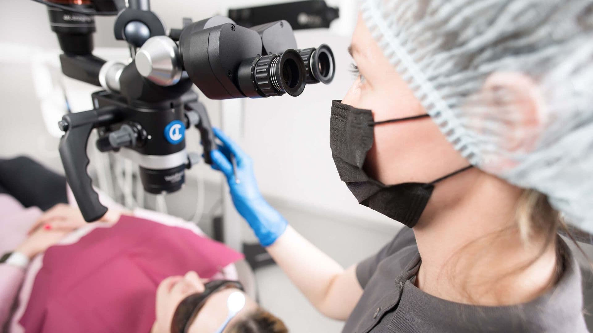 Dentist using a dental microscope during a root canal treatment