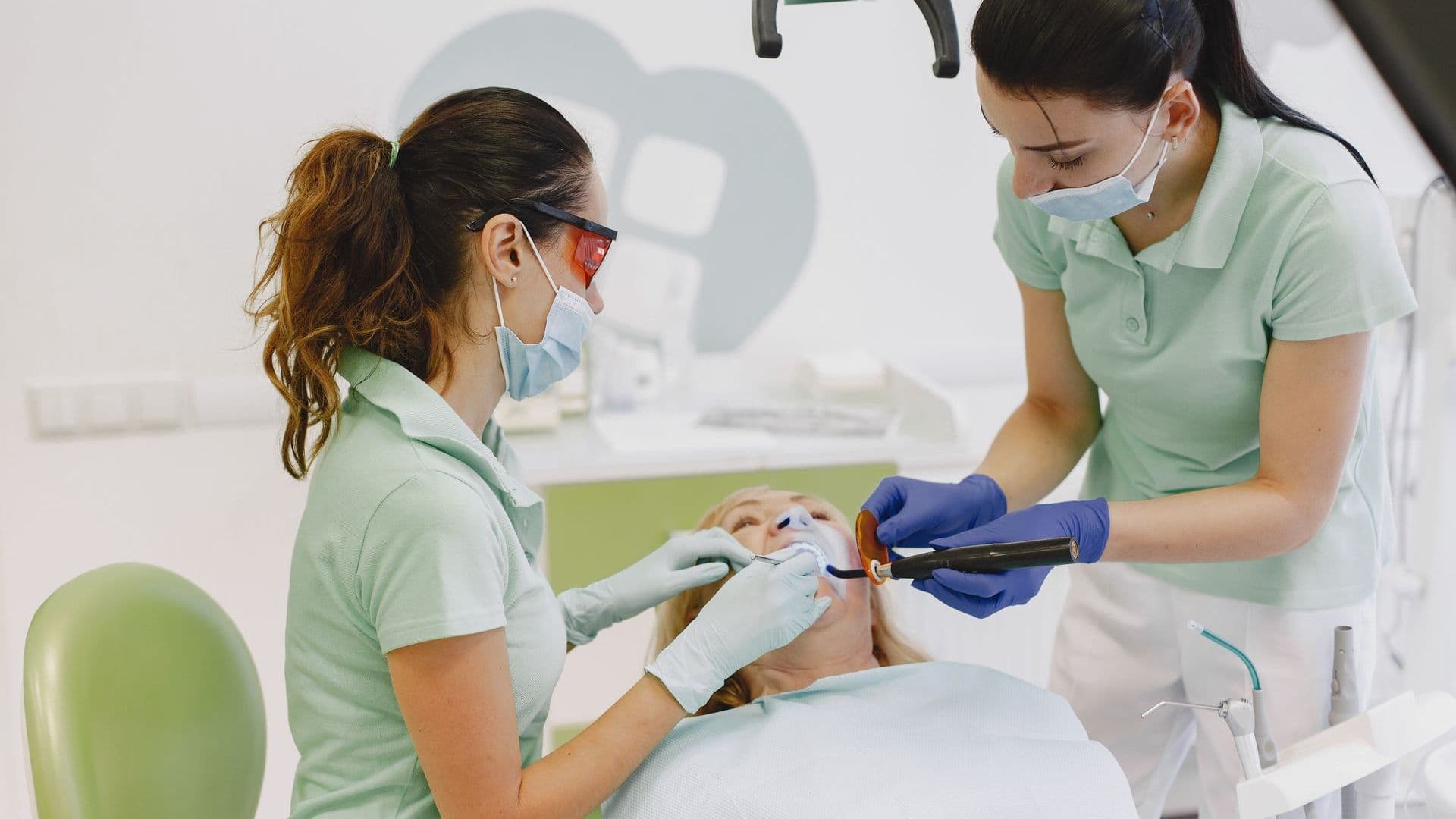 Dentist and assistant treating a patient with a white filling
